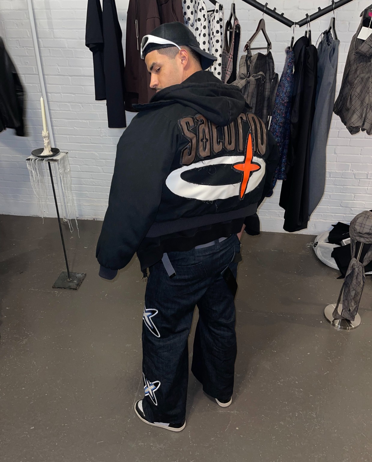 Back view of a visitor wearing a reconstructed graphic jacket at the LDF showroom during Montréal Fashion Week 2026.