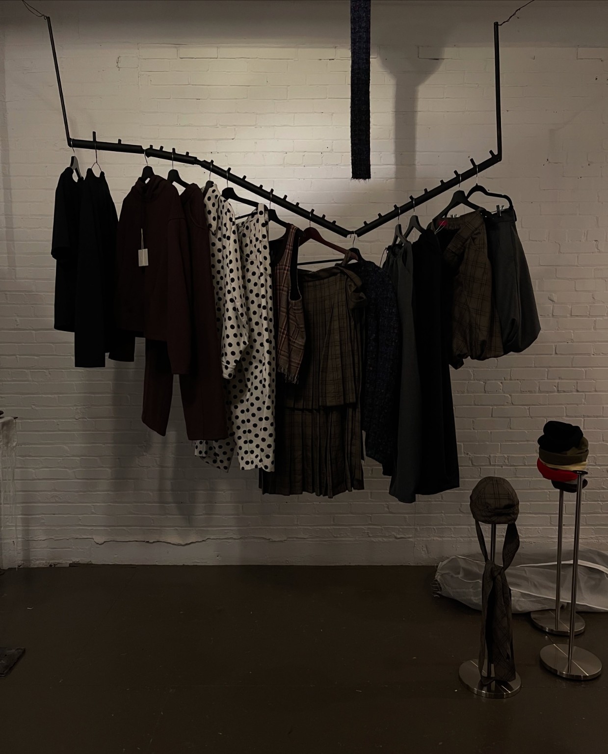 Independent fashion garments arranged on a sculptural display rack at the LDF showroom during Montréal Fashion Week 2026.