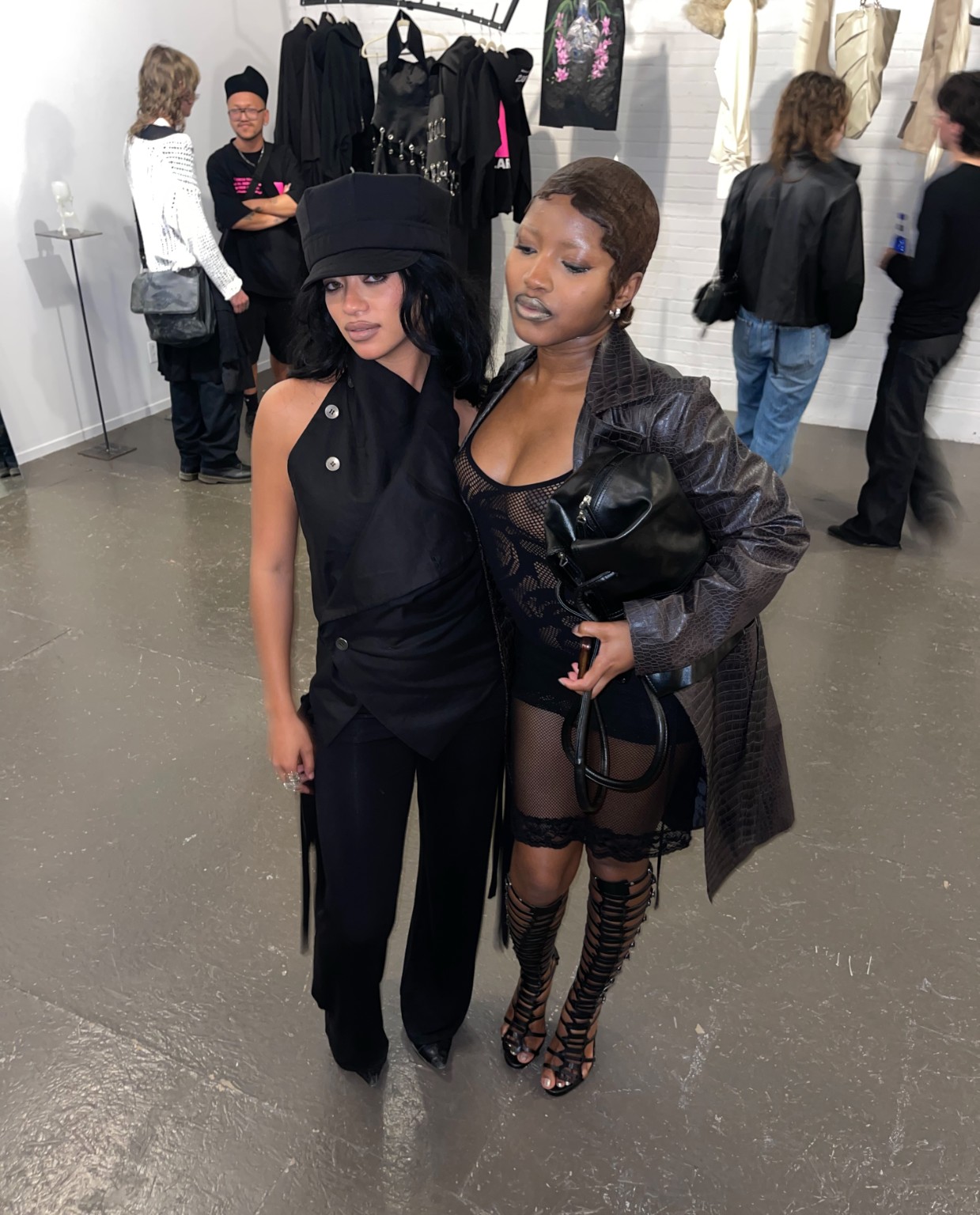 Two visitors wearing black looks inside the LDF showroom during Montréal Fashion Week 2026.